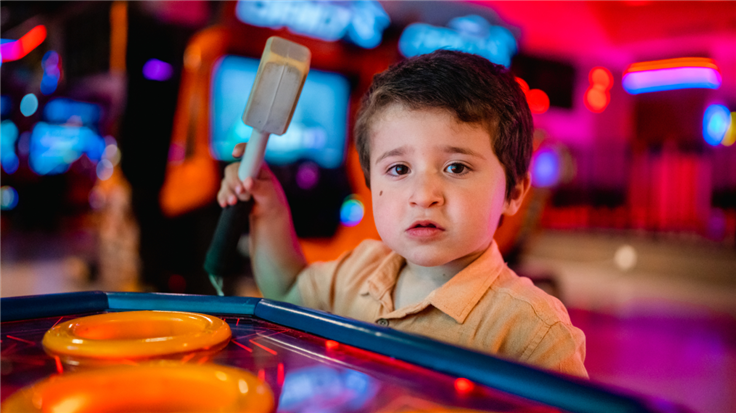 Little boy playing whack a mole